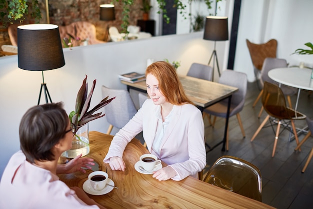 テーブルでお茶を飲みながら話す二人の女性